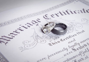 Two wedding rings on a marriage certificate emphasize HPRC resources for building healthy relationships and improving well-be