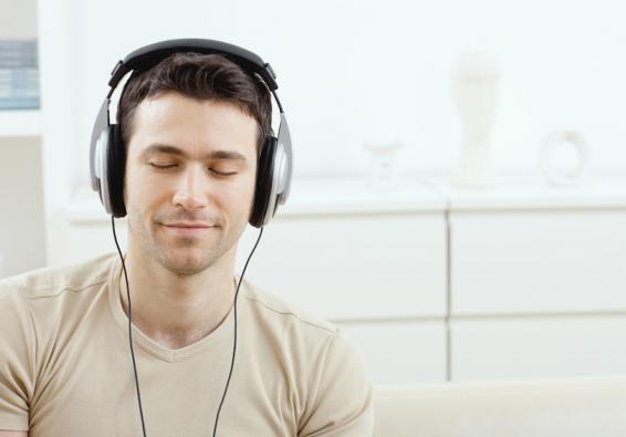 Man listening to headphones with eyes closed practices autogenic training to manage stress and improve mental fitness  