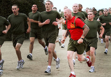 Drill instructor motivating recruits during a run emphasizes total force fitness for military readiness and performance   U S