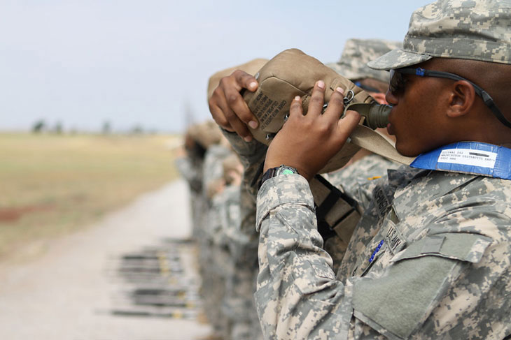 Service member drinks water from his 2-quart canteen while at the zero range with the 1st Battalion, 79th Field Artillery. (U.S. Army photo)
