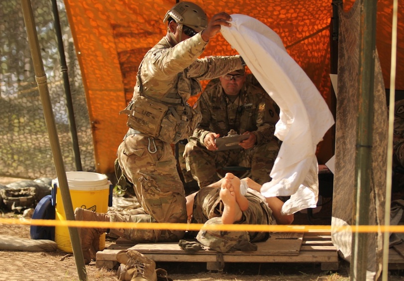 Service Member rests after heat injury collapse during military workout and military medic provides care to using HPRC and WH