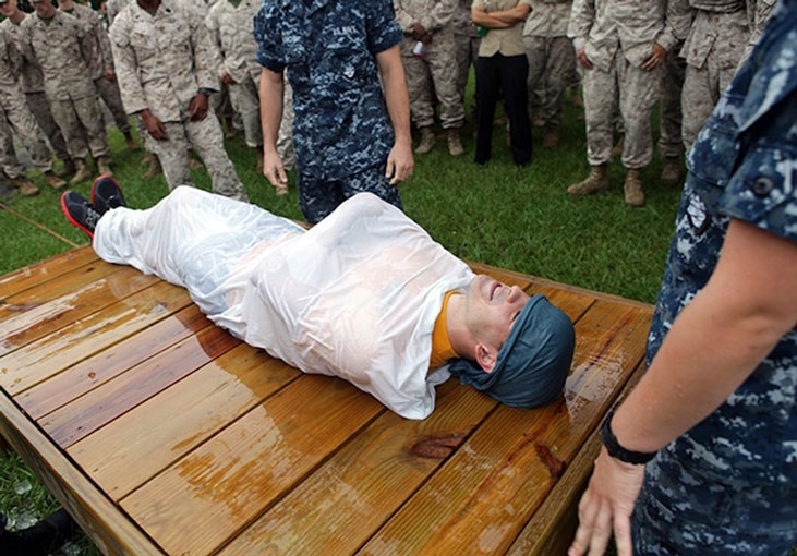 Navy Petty Officer 3rd Class Ryan Adams is being used as an example victim for cooling a heat casualty at the bi-annual hot weather standard operating procedure training aboard Marine Corps Base Camp Lejeune, N.C., Aug. 24. Adams is demonstrating the "burrito" method used to cool a heat related injury victim. Photo by Pfc. Joshua Grant.