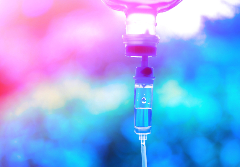 A saline drip device against a pink and blue background shows an injury prevention strategy for heat illness during military 