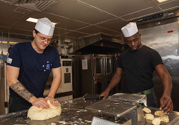 Service Members preparing bread for military dining facility. U.S. Navy photo by Mass Communication Specialist 3rd Class Levi Decker