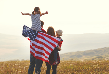 family wrapped in American flag outdoors