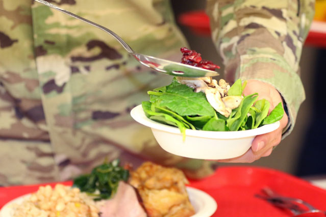 A soldier builds a salad at a DFAC