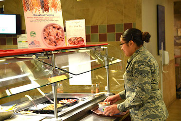 An Airman builds her meal using fresh, health options (U.S. Air Force photo by Carrie Grover)