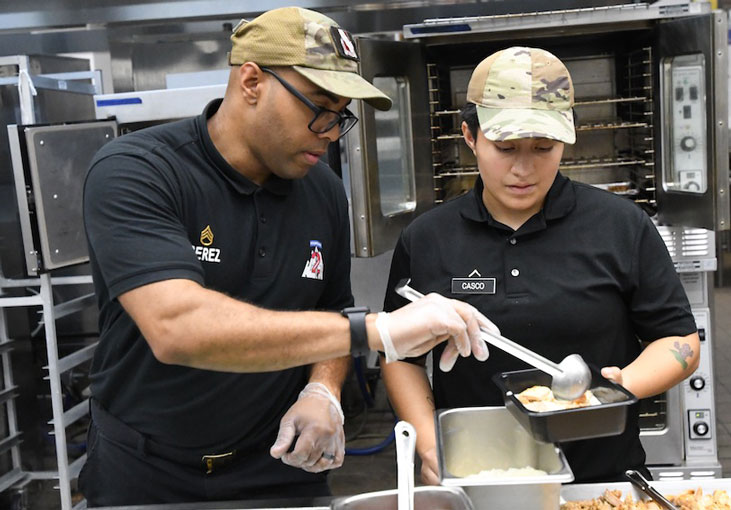 Culinary specialists in the 2nd Brigade Combat Team Commando Warrior Restaurant work on to-go meals under the new Performance
