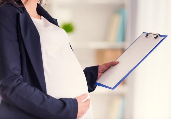 Pregnant woman holding a clipboard prepares for parenthood with military service-specific health resources  
