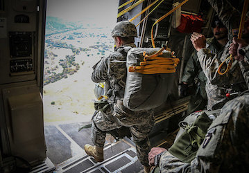 Soldiers practice teamwork and resilience as one steps out of airplane door during military training jump   U S  Army Nationa