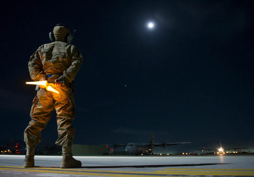 Airman prepares to guide a C-130J Super Hercules onto a taxiway during a night shift which she prepared for using HPRC Total 