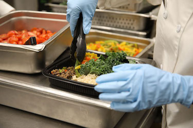 Culinary specialist adds the final touch to a Meal Prep to-go meal   U S  Army photos by Capt  Jessica George 