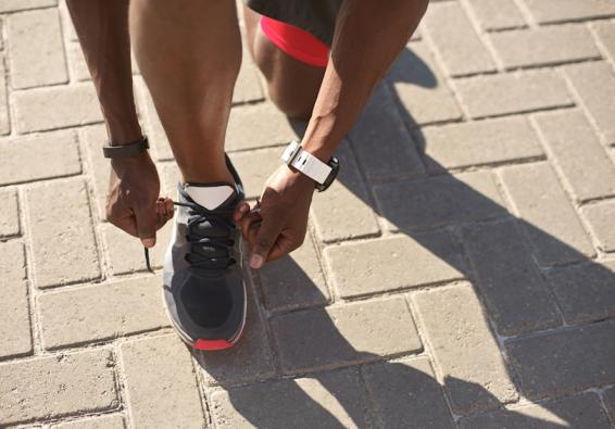 Man tying his running shoes optimizes his workout with HPRC injury prevention strategies  
